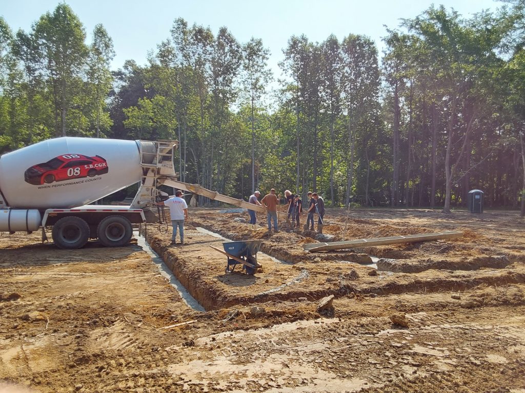 Builder pouring concrete in the footers