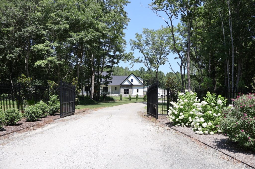 Custom Home Builder with landscaped entrance to property