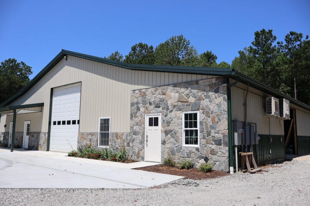 Home Builder finishes stone to exterior of shop build