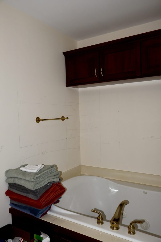 Before Bathroom Remodel with dated tub and cabinets above